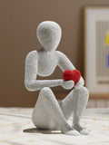 Textured Seated Figure Holding Red Heart Statue